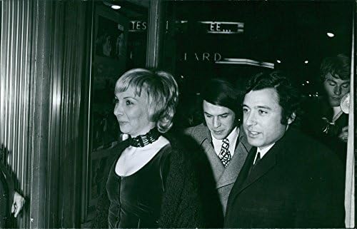 תצלום וינטג 'של סלווטורה אדמו ואשתו ניקול אדמו, מחייכת, עם גבר, נכנסים לבניין, 1970.