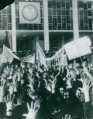 תצלום וינטג 'של אנשים התאספו בצד הרחוב, הרימו את ידיהם, אוחזים באנרים, עם שוטרים מעבר לרחוב, מרץ 1964.