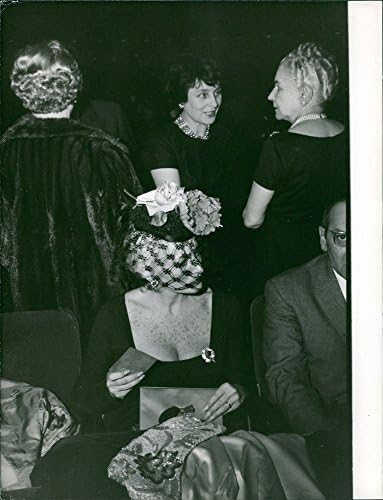 תצלום וינטג 'של פרננדה מונטל יושב, שתי נשים מדברות ברקע.