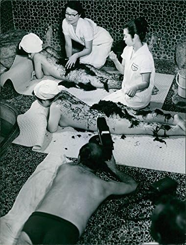 תצלום וינטג 'של שתי נשים ששוכבות עירומות מעסה על ידי המטפל בזמן הצילום.
