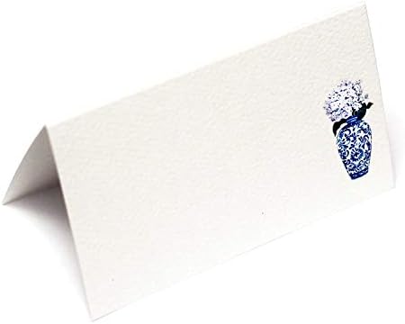ננסי ניקו מניחה קלפים עם צנצנת ג ' ינג ' ר כחולה ולבנה עם פרחים לבנים לחתונות, מקלחות ומסיבות ערב. שולחן